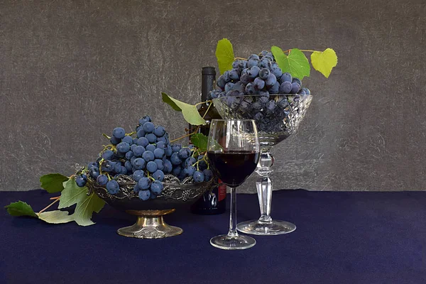 stock image Two grape varieties in vases and and a glass of red wine.