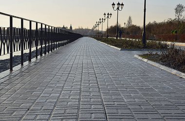 The sidewalk along the embankment is completely covered with ice.