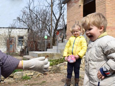 Küçük bir çocuk elinde bir cırcır böceğini muayene ediyor..