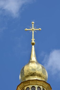 Cross on the bell tower of St. Sophia Cathedral in Kyiv against the sky.