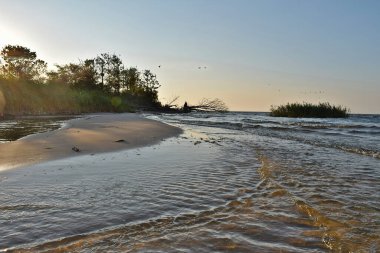 Sahildeki dalgaların aşınmasından dolayı adanın yakınında bir kum tükürüğü oluştu..