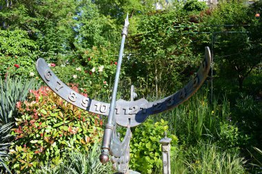 Parkta yarım daire şeklinde bronz bir güneş saati..