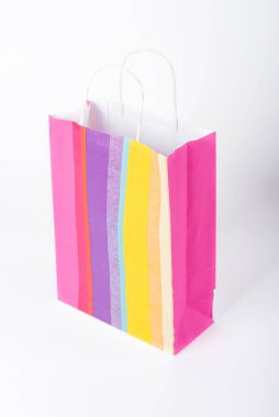 Beyaz arka planda izole edilmiş parlak renkli bir hediye çantası..