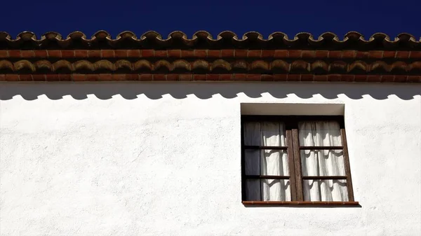 屋根を背景に空を背景に白い建物のファサードの窓 — ストック写真