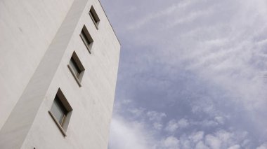 Gökyüzüne karşı binadaki pencereli beyaz cephe