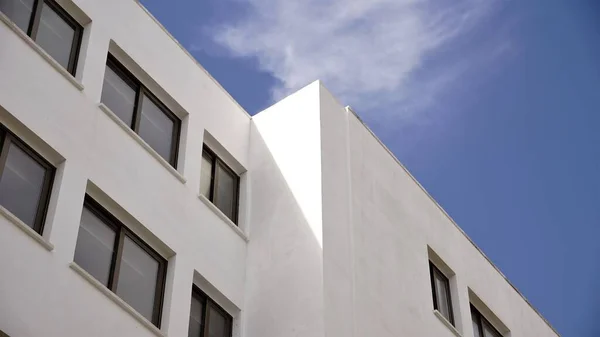 Niski Kąt Białej Elewacji Nowoczesnego Budynku Przed Błękitnym Niebem — Zdjęcie stockowe