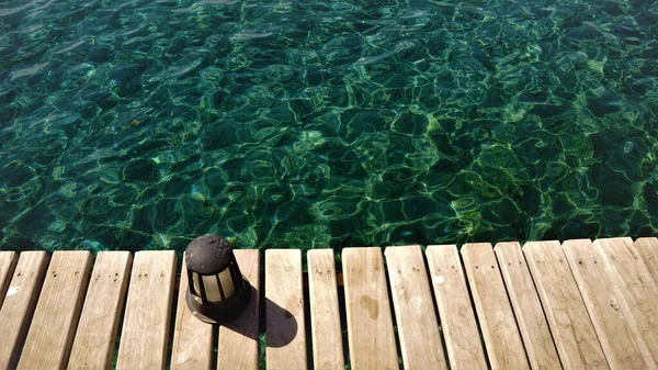 海に浮かぶ木製の桟橋を背景に — ストック写真