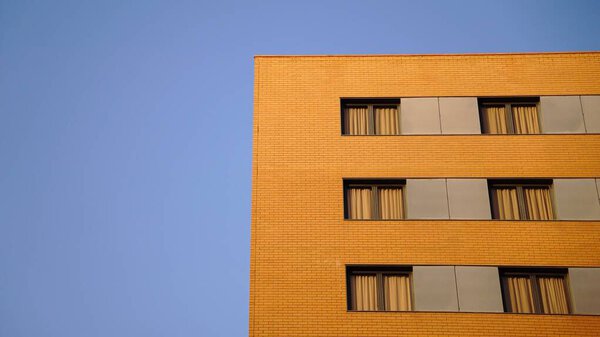 Windows in minimalist red brick building facade against the sky