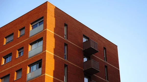 Gökyüzüne karşı kırmızı tuğlalı binanın köşesi.