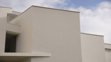 Mavi gökyüzüne karşı beyaz cepheli modern binanın soyut yapısı