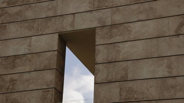 Taş cephede bulutlu gökyüzüne bakan pencere