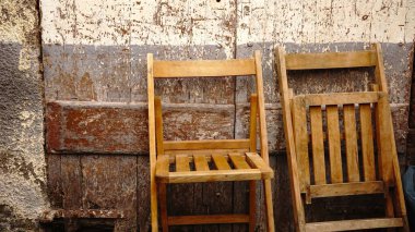Yıpranmış duvara karşı ahşap katlanır sandalyeler