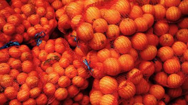 arkaplan olarak torbalar içinde portakal yığını