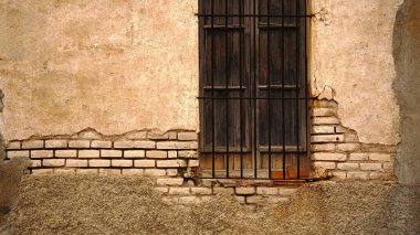 Arka plan olarak yıpranmış ön cephede ızgara ile pencere