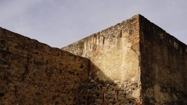 Gökyüzüne karşı yıpranmış taş cephe