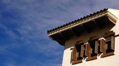 Gökyüzüne karşı ön cephede kepenkleri olan pencereler