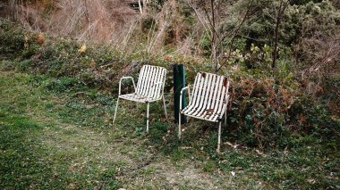 Yeşil alanda beyaz sandalyeler