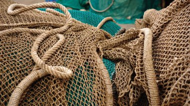 İskeleye yığılmış balık ağları ve ipler.