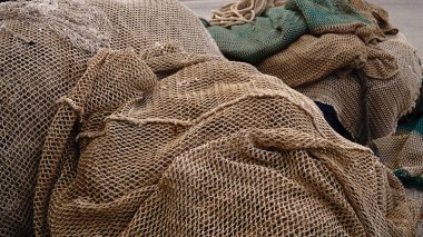 İskeleye sade balık ağları yığılmış.