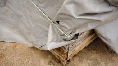 Ahşap kutuyu kaplayan gri branda branda.