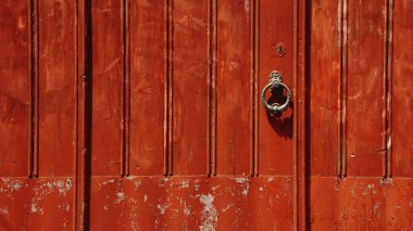 Kırmızı ahşap kapının metal sapı.