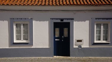 Mavi kapılı ve ikiz pencereli beyaz cephe