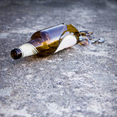 Parçalanmış bira şişesi yerde dinleniyor - alkolizm konsepti