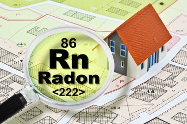 The danger of radon gas in our homes - concept with presence of radon gas under the soil of our cities and buildings with magnifying glass