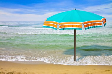 Calm sea with beach umbrella - concept image with copy space