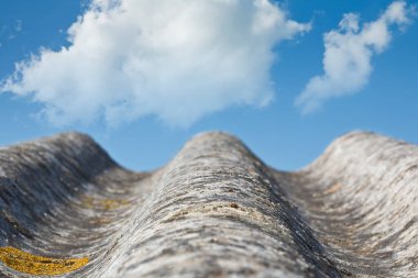 Old aged dangerous roof made of corrugated concrete asbestos panels - reduced deep of field concept