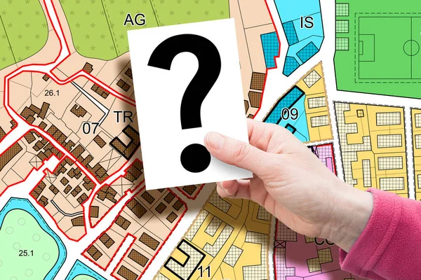 Imaginary General Urban Plan concept - zoning regulations with zoning districts, urban destinations, land use, buildable areas and land plot - concept with hand holding a card with question mark