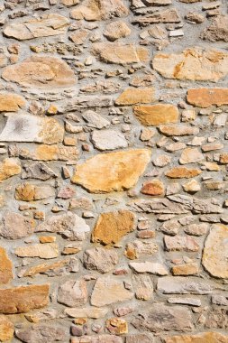 Düzensiz şekillendirilmiş taş bloklarla inşa edilmiş eski bir duvar.