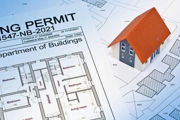Building Permit concept with imaginary building approvation and residential home against a cadastral map and General Urban Planning