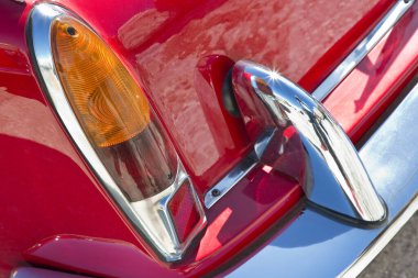 Detail of a tail light of a vintage italian red sport car