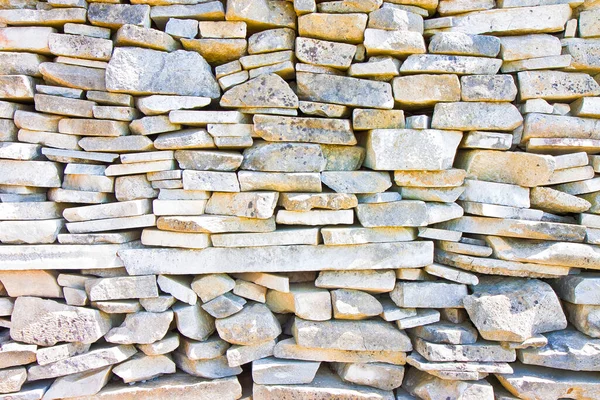 Stone wall built with blocks and marble slabs simply placed over one another