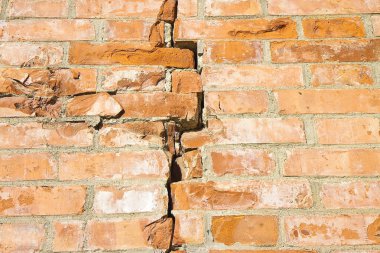 Old brick wall cracked and damaged due to structural failure, subsidence or damage from earthquake 