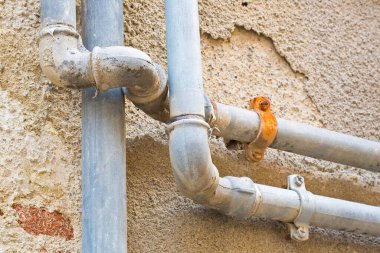 Metan gazı ve su metali borusu bir apartmanın duvarına dayanmış.