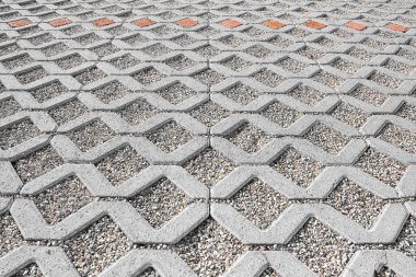 Beton kaplama kiremit ve boşaltma zemin blokları çakıllı bir kum tabakası üzerine monte edildi - araba park alanlarında yasaların gerektirdiği gibi yağmur suyuna geçirgen döşeme tipi