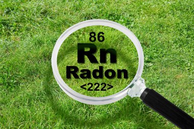 Yerin altındaki tehlikeli radyoaktif doğal radon gazı - elementlerin periyodik tablosu, büyüteç ve yeşil çimen alanı kavramı