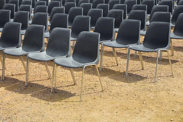 户外电影院 有一排黑色塑料椅子 在砾石地板上 — 图库照片