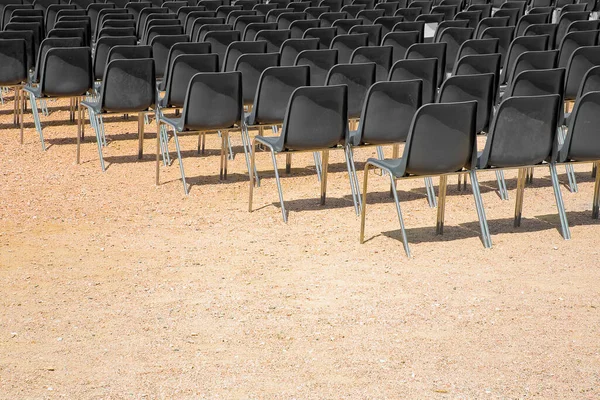 户外电影院 有一排黑色塑料椅子 在砾石地板上 — 图库照片