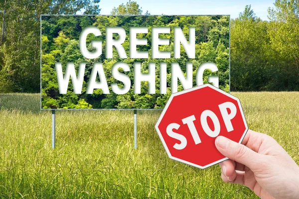 stock image Stop Greenwashing concept with advertising signboard in a rural scene with trees on background and hand holding a stop sign