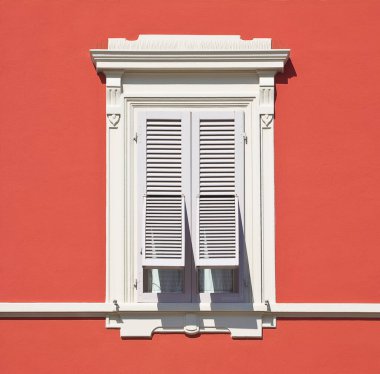 Eski bir neoklasik italyan penceresi, ahşap kepenk ile kırmızı renkli alçı bir duvara karşı - İtalya