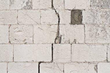 Old deeply cracked and damaged stone wall cause due to subsidence of foundations structural failures  clipart