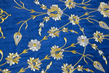 Altın geometrik ve çiçekli eski Türk işlemeli kumaşı mavi arka planda