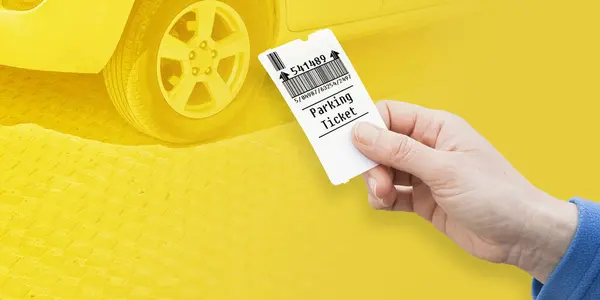 Female hand holds a parking ticket - parking payment concept