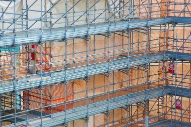 İnşaat alanındaki metal iskeleler prefabrik bileşenlerle inşa edilmiş. Binanın ön cephesinde güvenli bir şekilde çalışabilmek için.