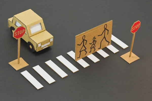 Black and white pedestrian crossing with cardboard stopped car and pedestrians cross the road safely - cartoon concept