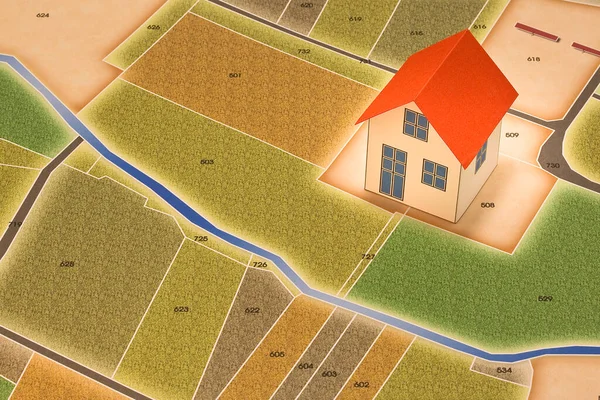 New home and free vacant land for building activity in rural land - Construction industry concept with a model of rural building and imaginary cadastral map