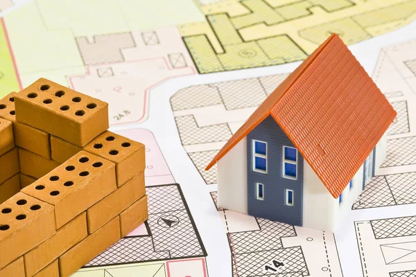 stock image General Urban Plan and zoning regulations map with buildings and home model with small terracotta bricks - house construction and building activity concept